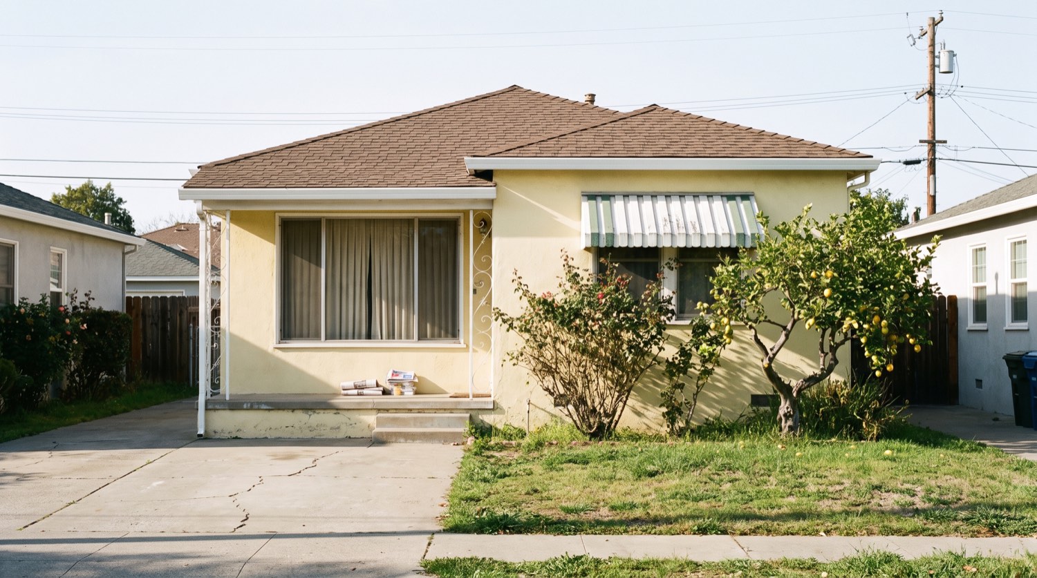 A long-held 1950s Bay Area stucco bungalow with a mature garden and drawn curtains — the kind of family home that passes through probate, which Eugene buys as-is for cash